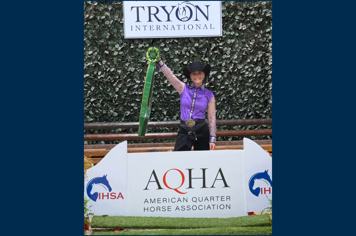 Student with wearing cowboy hat raising green ribbon with long streamers